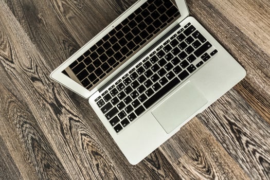 Laptop placed on a wooden surface in a cozy indoor workspace during daylight hours photo