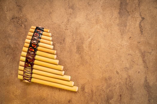 bamboo pan flute instrument from Peru against textured art paper with a copy space photo