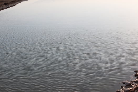 A man is standing on a rock next to a river photo