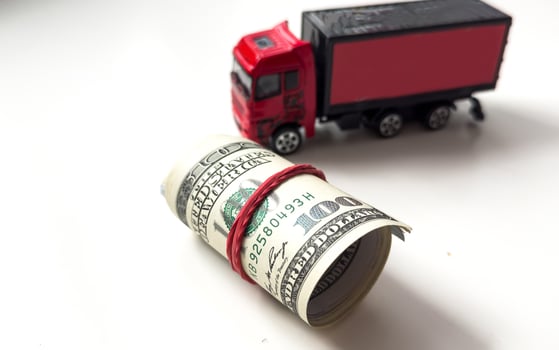 A toy truck carries a dollar rolled photo