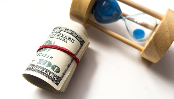 Hourglass on background of dollar bills photo