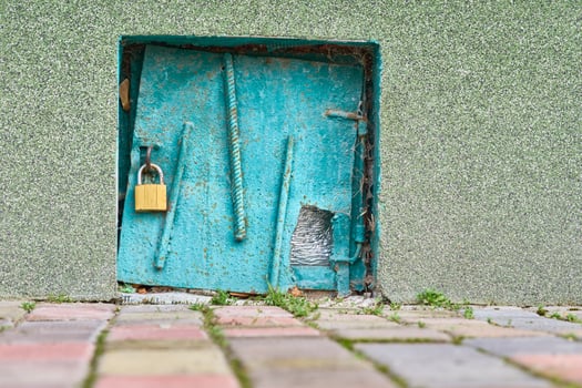 Old small door in the wall for a water hydrant, closed with a padlock photo