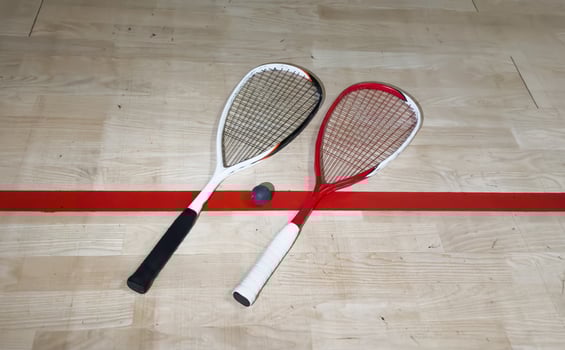 Squash rackets and ball on court floor, top view photo