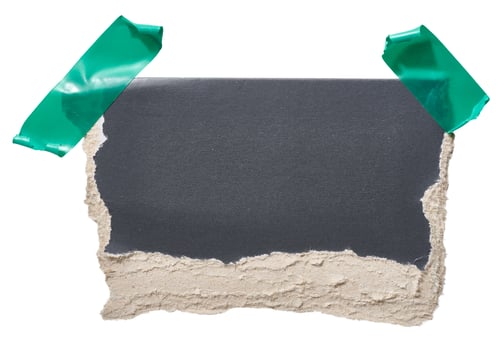 Torn piece of black cardboard attached to green piece of electrical tape, isolated background photo