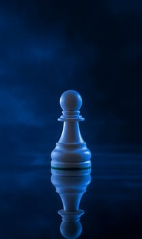 Pawn in blue spotlight with reflection, Strategy, intellect, and the game of life photo