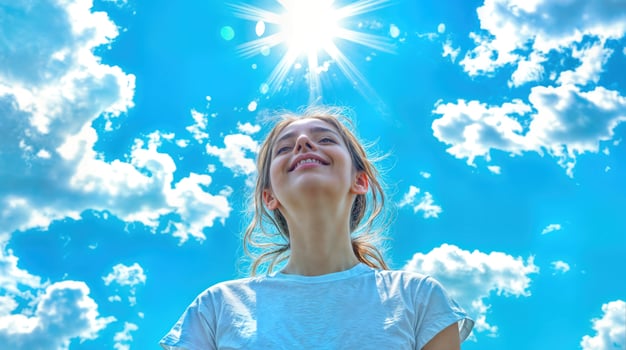 A woman is looking up at the sun photo