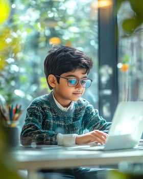 Young boy with glasses focused on using a laptop indoors, surrounded by greenery and soft lighting. photo