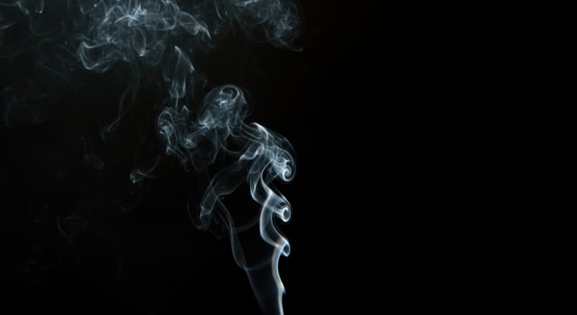 A dramatic image of smoke swirling in the air, creating intricate patterns as it rises. photo