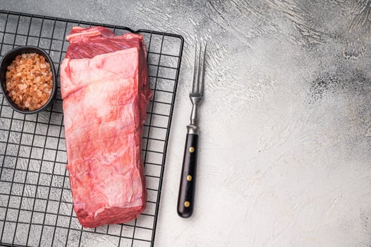 Close-up of raw buffalo meat cuts, highlighting the marbling and vibrant hue, perfect for creating delicious and nutritious dishes. grey background. top view photo