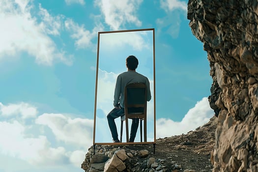 A man sitting on a chair looking out a window photo