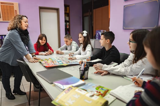 Woman teaching a group of elementary students at language school photo