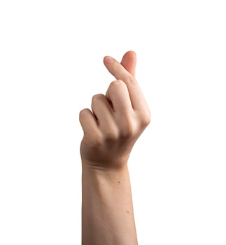 Female hand making a love sign gesture, fingers forming a popular Korean symbol of affection and photo