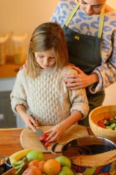 She proudly shows her mom the neatly cut slices, eager for approval. photo