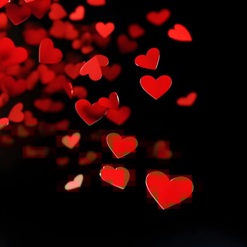Red Hearts Falling Gracefully on Black Background Representing Love and Romance photo