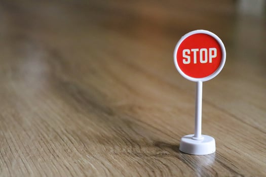 A Small Miniature Stop Sign Placed Upon a Wooden Floor Surface for Emphasis and Design photo