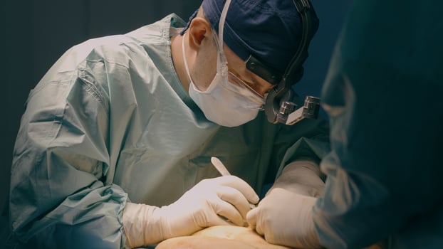Two doctors operating patient in clinic hospital surgeon man medic physician perform surgical operation cesarean section abdominal plastic surgery cut stomach abdomen with scalpel medicine health care photo