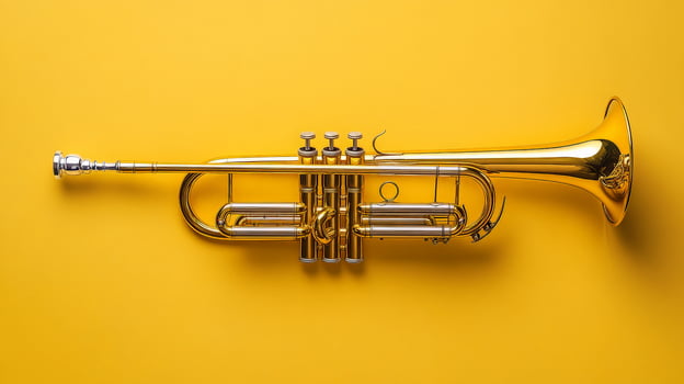 Shiny brass trumpet on vibrant yellow background photo