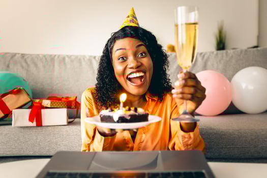 Online Birthday. Excited African American Woman Celebrating B-day Showing Cake With Candle And Glass Of Wine To Laptop Having Call At Home. Modern Holidays Celebration photo