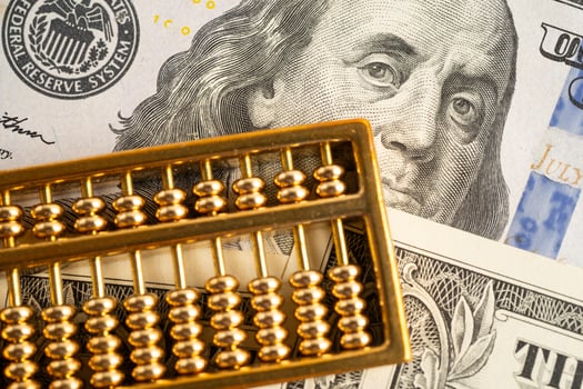 Gold abacus on US dollar banknote money, economy photo