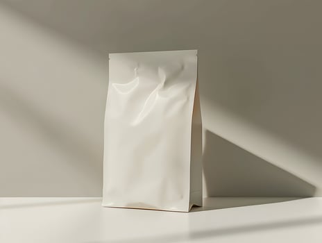 A white bag sitting on a table with a shadow photo