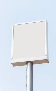 White mock up light box billboard on pole with blue sky background. Clipping path for mockup photo