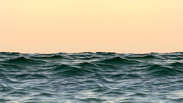 A view of the ocean at sunset with waves photo