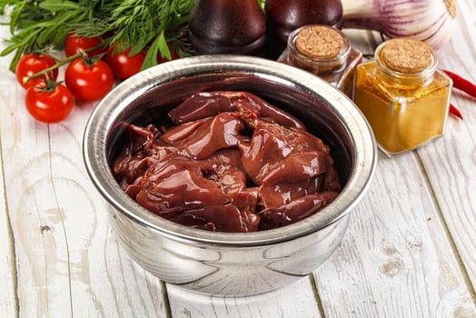 A bowl of meat and vegetables on a table photo