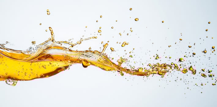 Golden honey creates energetic splashes as it flows through the air, forming unique patterns against a clean background. The liquids smooth texture contrasts beautifully with its vibrant color. photo