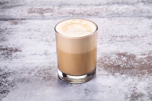 A coffee drink in a tall glass with cream photo