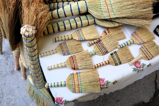 A Collection of Colorful Handcrafted Brooms Beautifully Displayed for Sale at Market photo