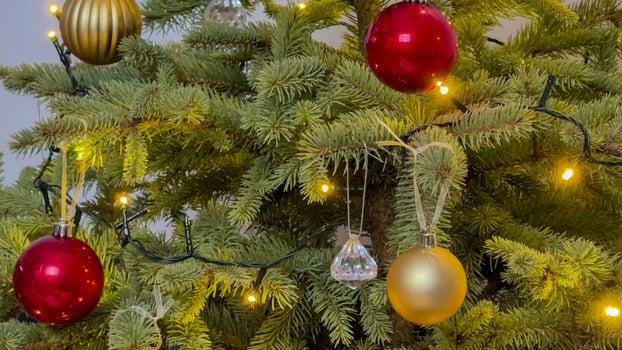Decorated Christmas tree with red and gold ornaments and twinkling lights, representing holiday celebration and festive spirit photo