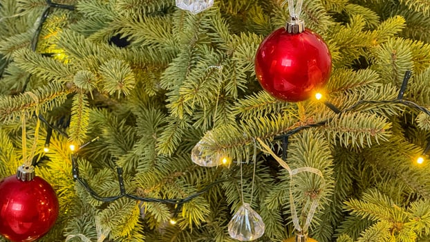 Close up of a Christmas tree adorned with red ornaments and lights, capturing festive holiday spirit and celebration photo