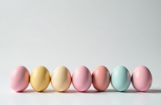 Multicolored pastel Easter eggs lined up on a white surface, festive design photo