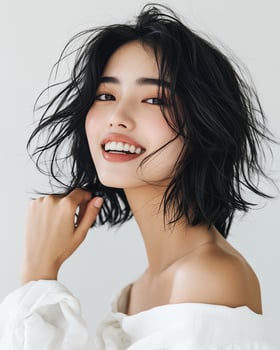 Beautiful young woman with short, wavy black hair and a bright smile. Studio portrait. photo