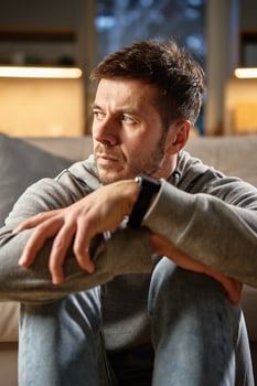 Thoughtful man sitting alone at home photo