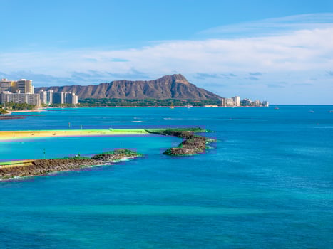 Turquoise waters, golden sands, and Honolulu's skyline frame Waikiki Beach, with Diamond Head Crater rising in the background under a clear sky. photo