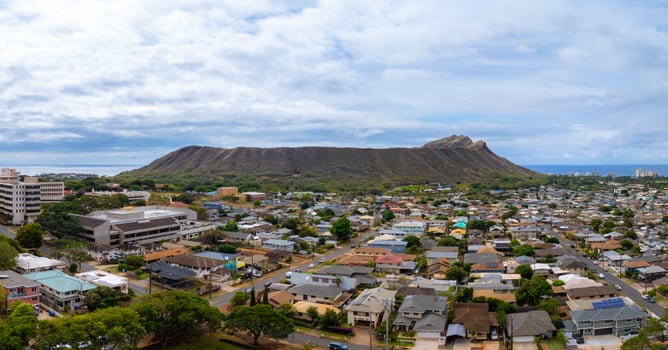 Aerial view of a residential neighborhood on Oahu island, Hawaii, with Diamond Head crater in the background and the ocean visible in the distance. photo