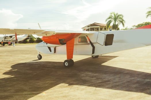Airplane on a runway with a clear sky and palm trees in the background, showcasing aviation and travel photo