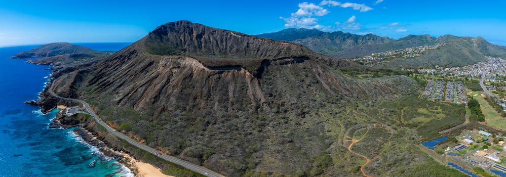 Aerial view of Diamond Head Crater on Oahu Island, Hawaii, with lush greenery, coastline, residential areas, a highway, and the Ko olau Mountain Range. photo
