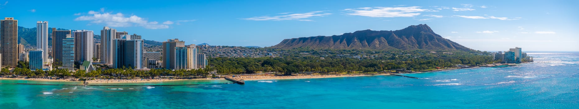 Aerial view of Waikiki Beach in Honolulu, Oahu, Hawaii, featuring high rise buildings, turquoise waters, sandy shores, and Diamond Head Crater. photo