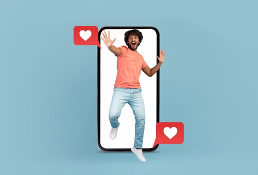 A cheerful young man jumps with excitement while holding a smartphone. Love-themed messages and hearts appear near the phone, highlighting social media and dating apps during Valentine's Day. photo