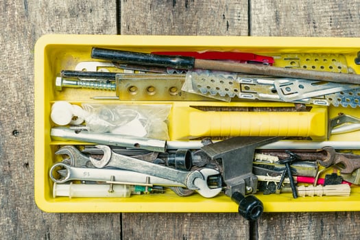 Tool box filled with various tools and implements on a rustic wooden surface in a workshop setting photo