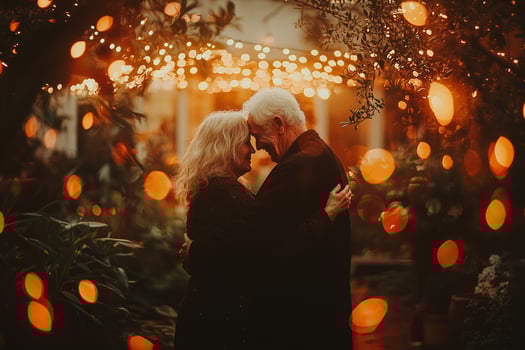 elderly Caucasian couple shares tender moment while dancing warm glow of string lights in their backyard. soft motion blur adds whimsical touch their joyful evening photo