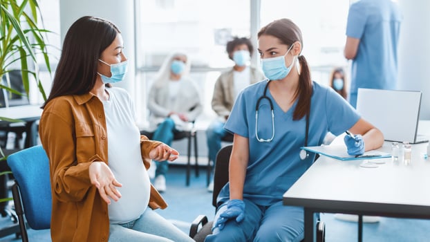 Coronavirus Vaccination Concept. Doctor Talking With Pregnant Asian Patient Before flu19 Vaccine Injection Sitting In Hospital, Asking About Medical History. Corona Virus Protection And Immunization photo