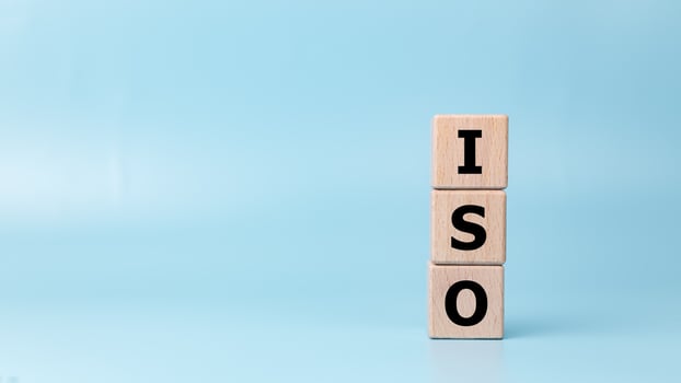 ISO, Standard certification standardisation quality control concept, Wooden blocks with the letters ISO for quality management of organizations on a light blue background, Certified and quality. photo