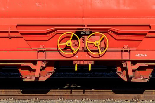 Detailed view of equipment on a red freight train car at a rail yard photo