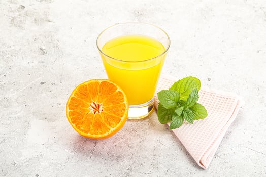 A glass of orange juice and a half eaten orange photo