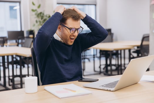 Businessman getting stressed and pulling his hair while working with his laptop in the office, he is screaming and shouting photo