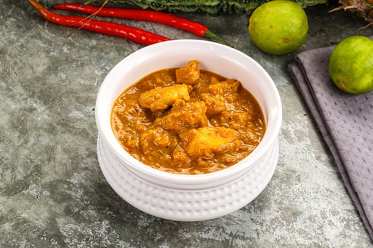 A bowl of curry with vegetables and spices photo