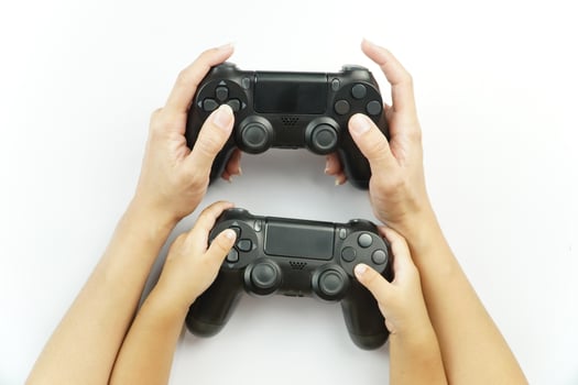 Two hands holding two game controllers on a white background photo